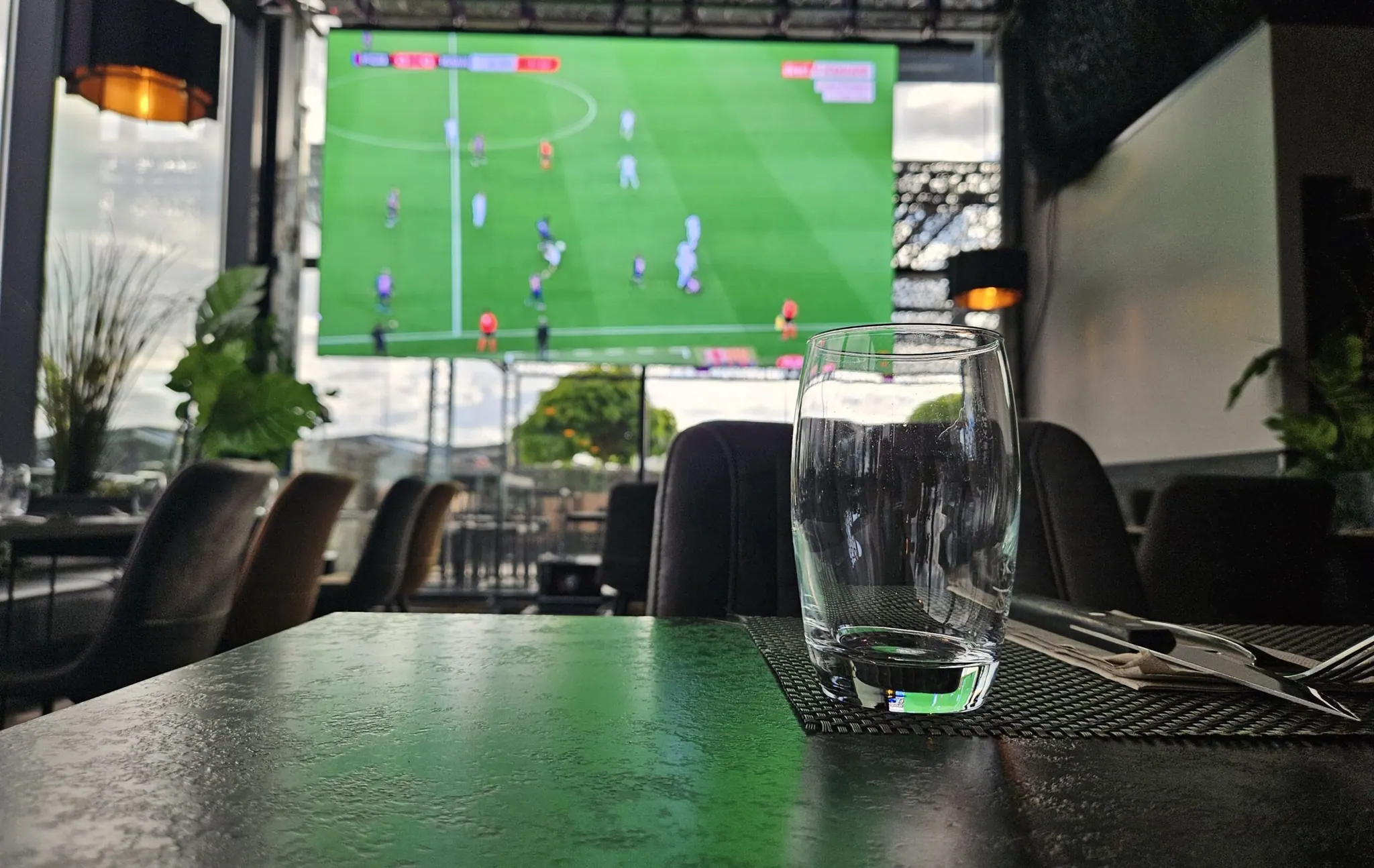 Retransmission d’un match de football sur un écran LED en terrasse